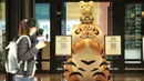 Warga berjalan melewati patung macan di depan pusat perbelanjaan jelang Tahun Baru Imlek di Taipei, Taiwan, 27 Januari 2022. Tahun Baru Imlek 2022 yang jatuh pada 1 Februari mendatang akan jadi tahun shio macan. (Sam Yeh/AFP)