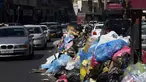 Kendaraan melintas di samping tumpukan sampah di sepanjang sisi jalan di Tripoli, ibukota Libya (30/9/2019). Berton-ton sampah berserakan dari tempat sampah dan menumpuk di pinggir jalan. (AFP Photo/Mahmud Turkia)