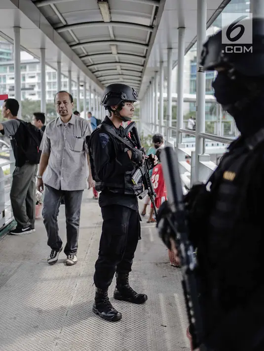 Dua anggota Brimob bersenjata lengkap berjaga di JPO kawasan Bunderan HI, Jakarta, Jumat (11/5). Penjagaan tersebut dilakukan untuk antisipasi kegiatan Aksi 115 Pembebasan Baitul Maqdis yang berpusat di Monas. (Liputan6.com/Faizal Fanani)