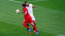 Penyerang Liverpool, Roberto Firmino (depan) berusaha melewati bek Sevilla, Daniel Carrico pada final Liga Europa di Basel, Swiss (19/5). Sevilla menang atas Liverpool dengan skor 3-1. (Reuters / Arnd Wiegmann)