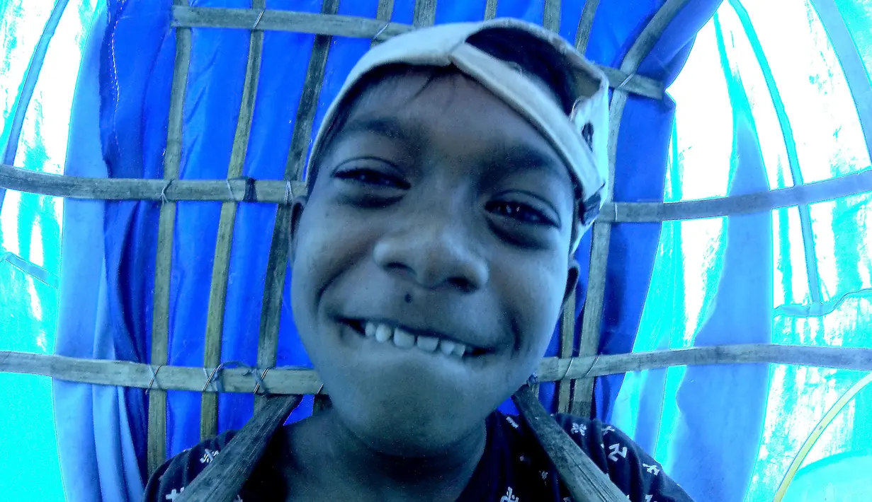 Foto pada 29 April 2019, Bastian (11) yang telah 3 tahun mengamen ondel-ondel berkeliling  di jalan-jalan Jakarta. Seiring berjalan waktu, ondel-ondel yang dahulu sebagai ikon kesenian Betawi kini mudah ditemui di sejumlah jalan dan gang-gang di antara permukiman warga. (GOH CHAI HIN / AFP)