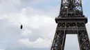 Seorang pengunjung meluncur dengan seutas tali saat melakukan flying fox dari Menara Eiffel, Paris, 5 Juni 2017. Kesempatan ini dibuka untuk umum jelang turnamen tenis French Open agar dapat merasakan bagaimana kecepatan bola tenis (FRANCOIS GUILLOT/AFP)