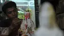 Pegawai toko penjual patung saat melakukan proses pengecetan di kawasan Medan Glodok Jakarta Barat, Kamis, (21/01).  Patung - patung ini mulai dicari pelanggan dalam menyambut hari raya Imlek. (Liputan6.com/Faisal R Syam)