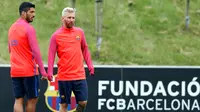 Penyerang Barcelona, Lionel Messi (kanan) dan Luis Suarez saat latihan bersama rekan setim di St Georges Park National Football Centre, Inggris, Senin (25/7). Messi tampil beda dengan rambut warna pirang. (REUTERS/ Darren Staples)
