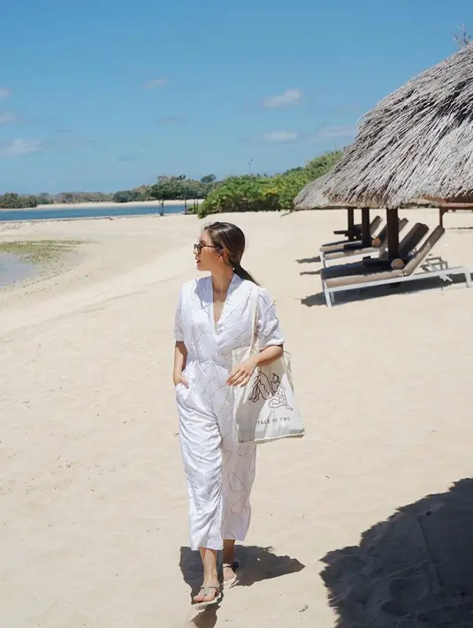 Berjalan santai di pantai, Jessica Mila nampak mengenakan pakaian bernuansa putih. Mulai dari jumpsuit, totebag, hingga sandal yang ia kenakan berwarna senada. (Liputan6.com/IG/jscmila)