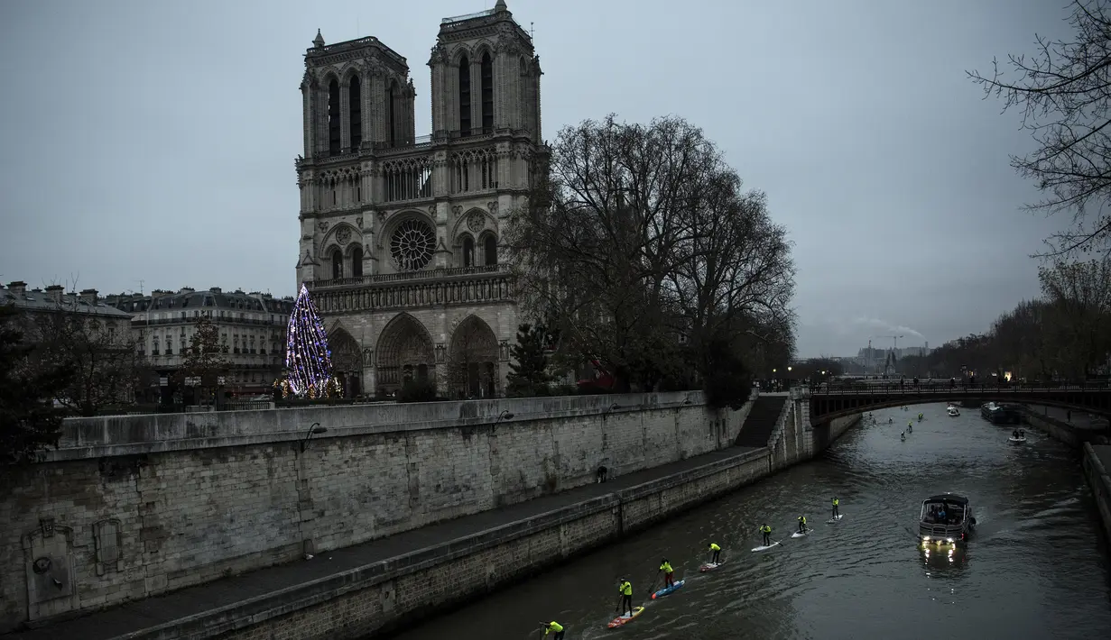 Peserta mendayung sambil berdiri selama mengikuti Nautic SUP Paris di sepanjang sungai Seine, Paris, Prancis, Minggu (3/12). Nautic SUP Paris merupakan lomba dayung sambil berdiri terbesar di dunia. (AFP PHOTO/CHRISTOPHE SIMON)