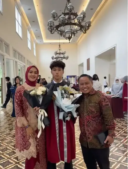 Athaya putra Narji baru saja lulus SMP, ia pun tampil mengenakan jubah maroon saat wisuda dipadukan celana panjang dan sepatu pantofel hitam. [@narji77]