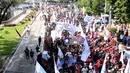 Massa buruh berjalan memasuki kawasan Jalan Medan Merdeka Barat, Senin (1/5). Aksi perayaan Hari Buruh Internasional oleh ribuan buruh tertahan di depan Kementerian Pariwisata akibat penutupan Jalan medan Merdeka Barat. (Liputan6.com/Helmi Fithriansyah)