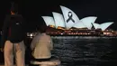 Layar ikonik Sydney Opera House telah diterangi dengan pita hitam pada Senin malam untuk mengenang para korban dan keluarga tragedi Bondi Junction. (AP Photo/Mark Baker)