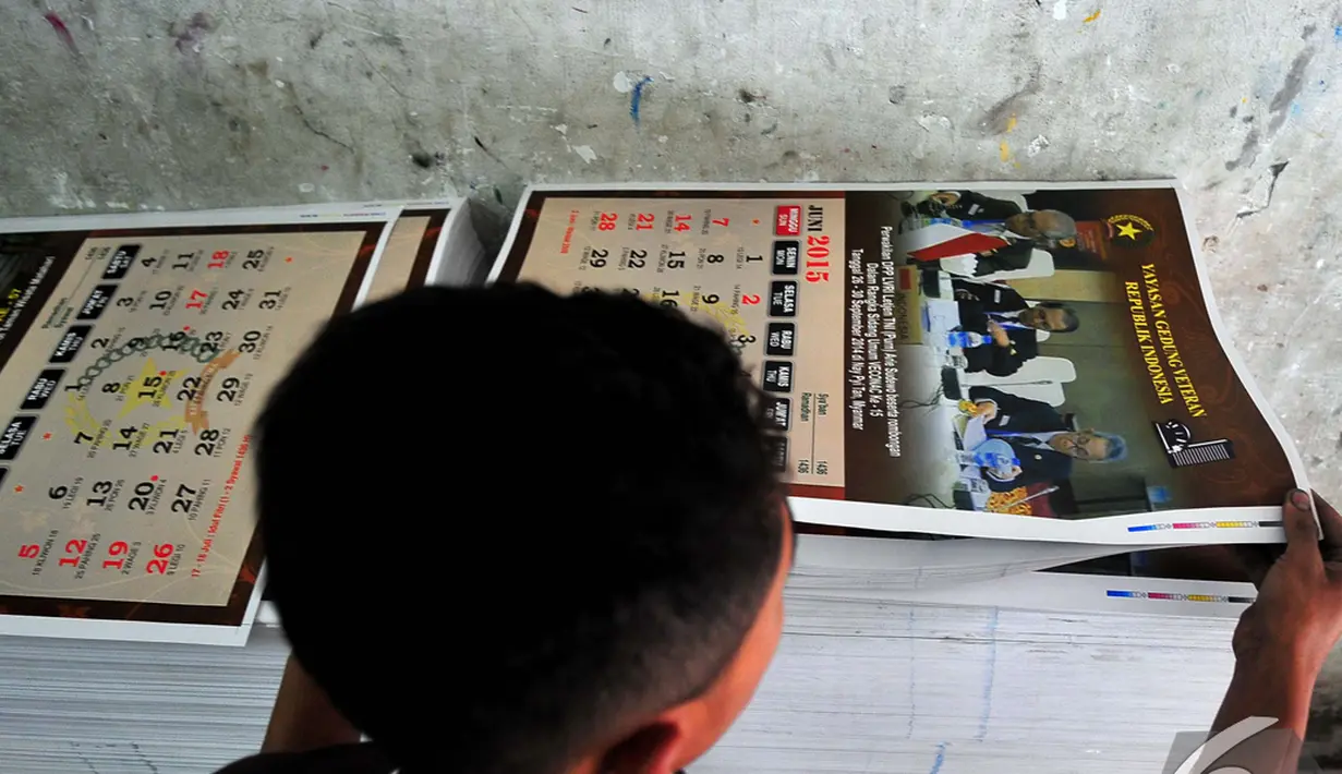 Seorang pekerja merapikan hasil pencetakan kalender 2015 di tempat percetakan, Senen, Jakarta, Senin (1/12/2014). (Liputan6.com/Johan Tallo)