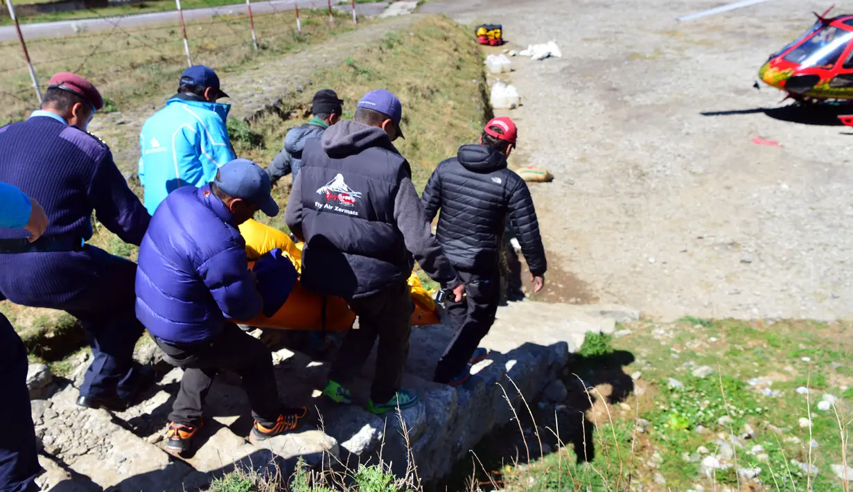 Petugas menggotong jasad kakek 85 tahun, Min Bahadur Sherchan, yang tewas saat mendaki Gunung Everest, Minggu (7/5). Pria asal Nepal tersebut diketahui ingin memecahkan rekor sebagai pendaki tertua di puncak tertinggi di dunia itu. (PRAKASH MATHEMA/AFP)