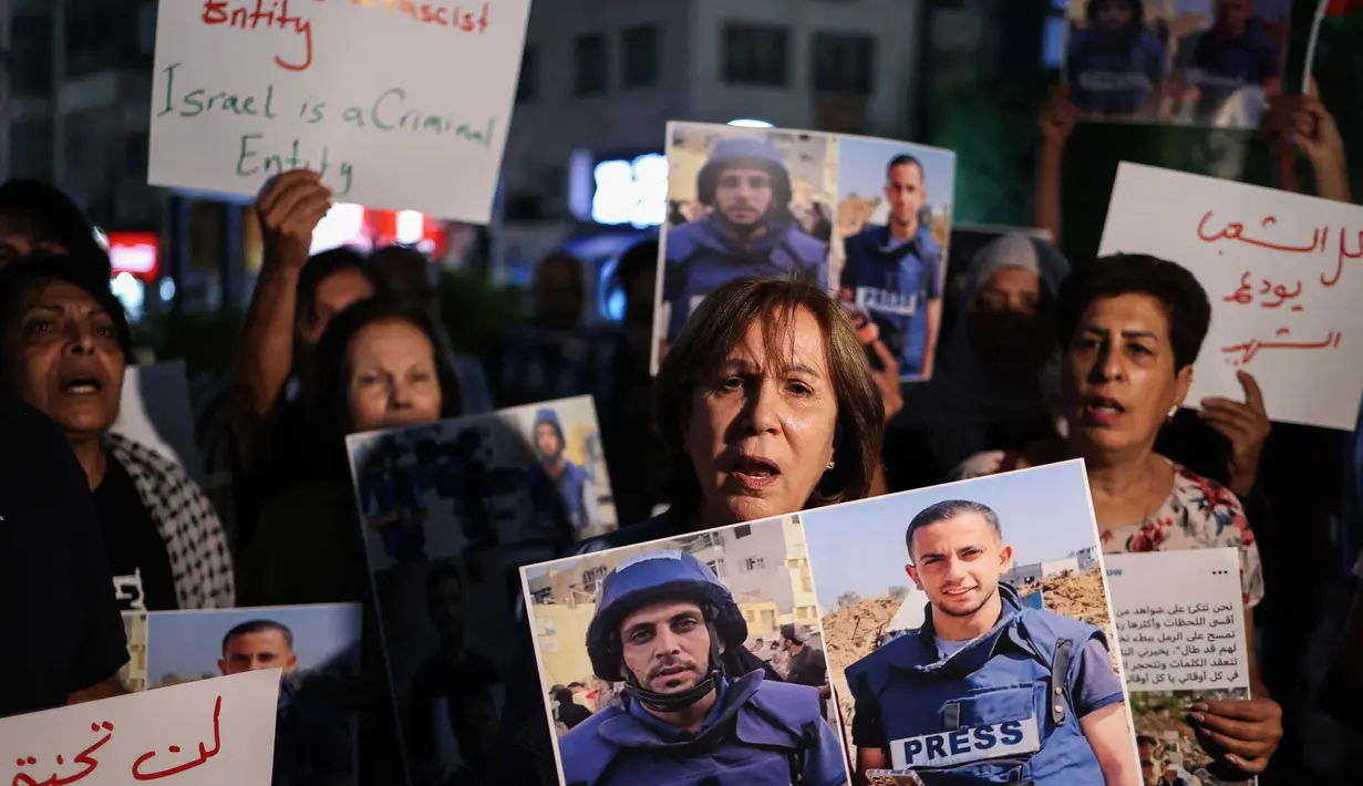 Para demonstran memegang foto dan spanduk yang mengecam pembunuhan jurnalis Al Jazeera dalam serangan Israel di Kota Gaza, selama aksi doa bersama di Ramallah, di Tepi Barat yang diduduki pada 11 Agustus 2025. (Zain JAAFAR/AFP)