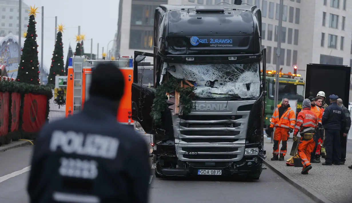Petugas berada di sekitar lokasi truk yang menabrak Pasar Natal di Berlin, Jerman, Selasa (20/12). Akibat kejadian ini, dikabarkan 12 orang tewas dan 48 orang terluka. (REUTERS / Hannibal Hanschke)