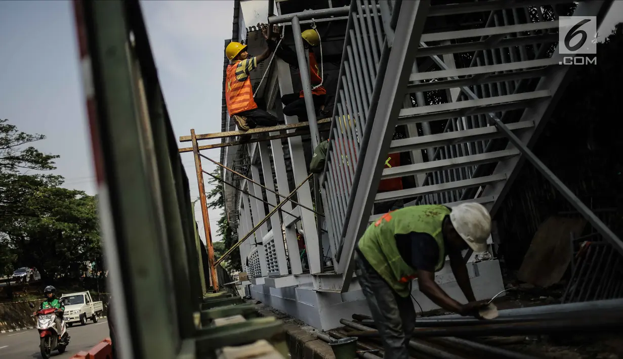 Pekerja menyelesaikan pembangunan halte busway BNN di Kawasan Cawang Jakarta, Jumat (2/3). Pembangunan halte baru tersebut guna menggantikan halte BNN yang lama akibat pembangunan proyek LRT. (Liputan6.com/Faizal Fanani)