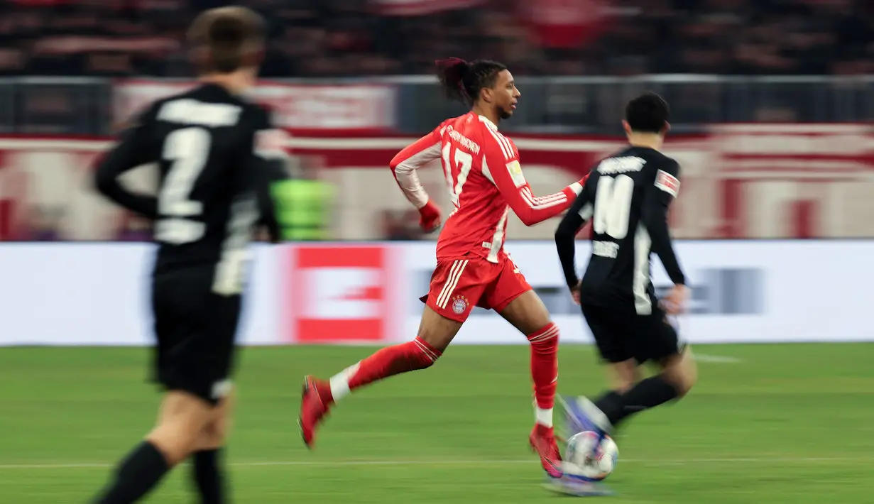 Pemain Bayern Munchen, Michael Olise menggiring bola melewati pemain VfL Wolfsburg dalam laga lanjutan Liga Jerman 2025/2026 di Allianz Arena, Munchen, Jerman, Minggu (11/01/2026) waktu setempat. (AFP/Alexandra Beier)