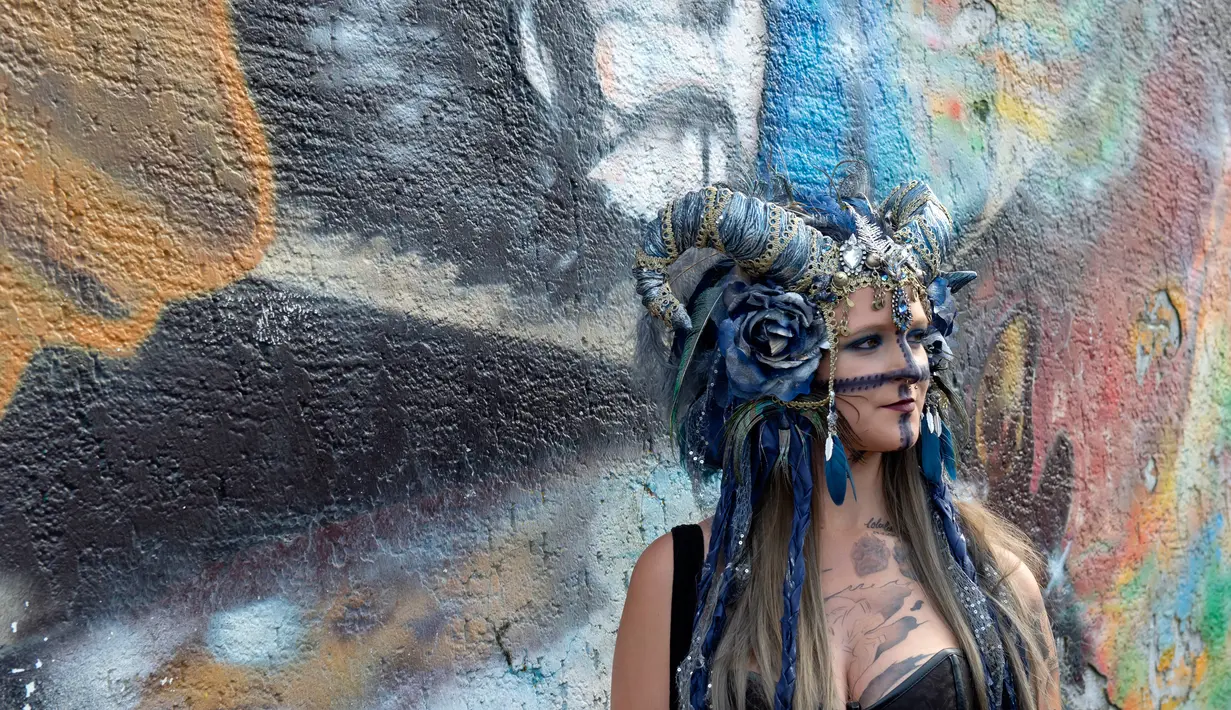 Seorang peserta dengan kostum nyentrik berpose saat hadir dalam Wave Gothic Festival (WGT) di Leipzig, Jerman, 19 Mei 2018. Untuk menarik perhatian, beberapa orang malahan berdandan ekstrim. (AP Photo/Jens Meyer)