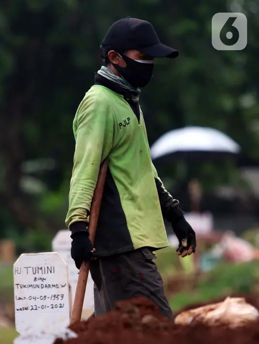Petugas bersiap merapikan makam jenazah dengan protokol COVID-19 di TPU Bambu Apus, Jakarta, Jumat (22/1/2021). Lahan pemakaman khusus dengan luas 3.000 meter persegi di TPU Bambu Apus ini diperkirakan mampu menampung 700 jenazah dengan protokol COVID-19. (Liputan6.com/Helmi Fithriansyah)