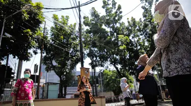 Sejumlah pegawai berjemur di bawah sinar matahari di Kawasan Fatmawati, Jakarta, Selasa (31/3/2020). Berjemur diri di bawah sinar matahari saat pagi merupakan salah satu upaya yang paling sederhana untuk menjaga kesehatan selama wabah virus COVID-19. (Liputan6.com/Faizal Fanani)