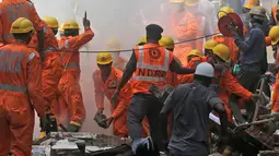 Petugas penyelamat berusaha mencari korban yang tertimbun akibat runtuhnya bangunan di Mumbai, India (31/8). Laporan lokal mengatakan hunian berlantai lima di Mumbai, India ambruk pada Kamis pagi waktu setempat. (AP Photo / Rafiq Maqbool)