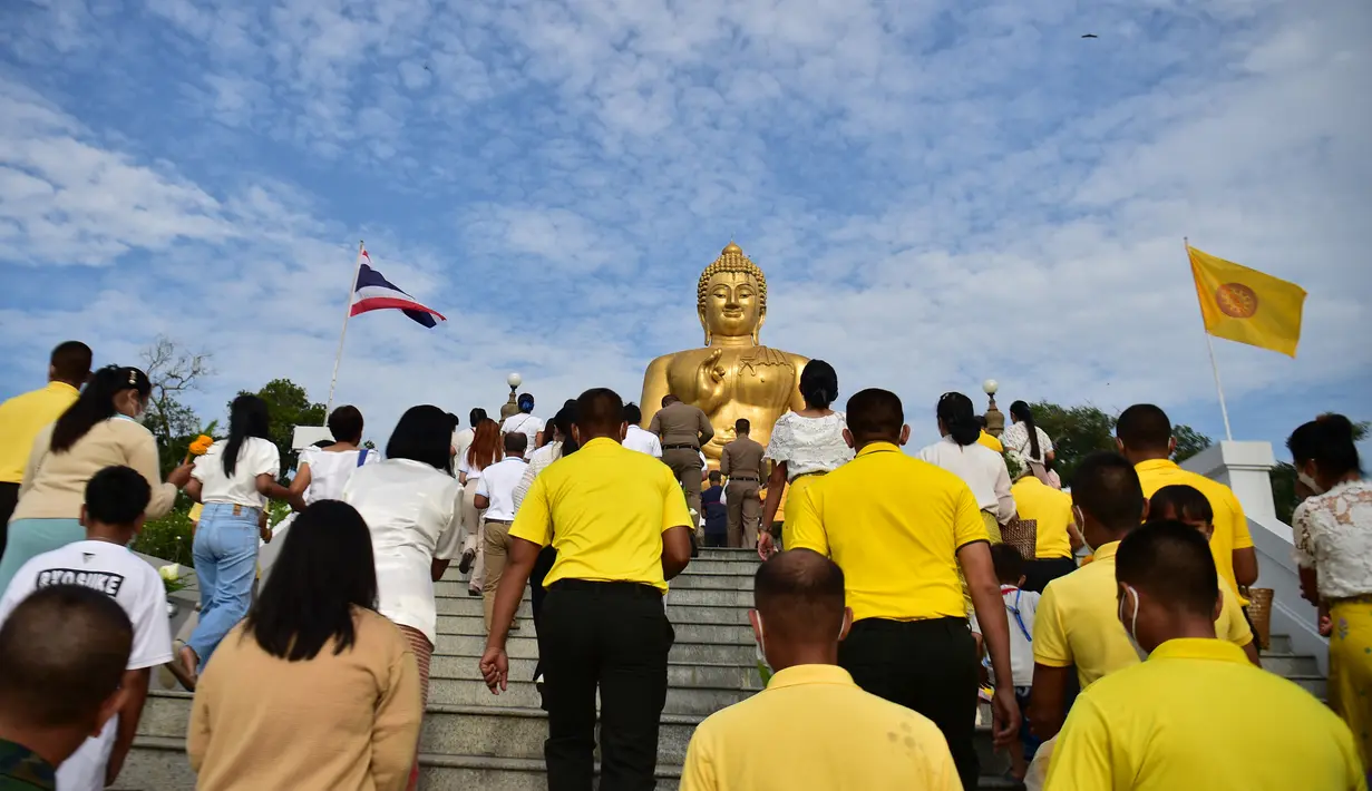 Umat Buddha menuju patung Buddha raksasa saat mereka memperingati Hari Makha Bucha di kota Narathiwat, Thailand selatan (6/3/2023). Hari raya ini dirayakan untuk mengenang suatu peristiwa ketika sang Buddha bertemu dengan 1250 murid pertamanya dan karena untuk mengenang peristiwa tersebut hari raya ini juga disebut sebagai hari raya Sangha. (AFP/Madaree Tohlala)