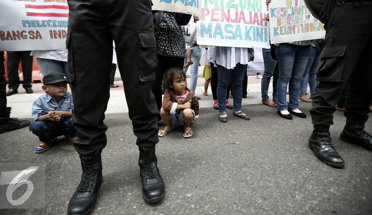 Dalam aksinya para buruh membawa anak-anak saat berunjuk rasa di Jakarta, Selasa (9/2). Mereka menuntut penyelesaian kasus PHK 1.300 buruh PT Panarub Dwikarya yang membuat sepatu Adidas dan Mizuno pada 2012 silam. (Liputan6.com/Faizal Fanani)