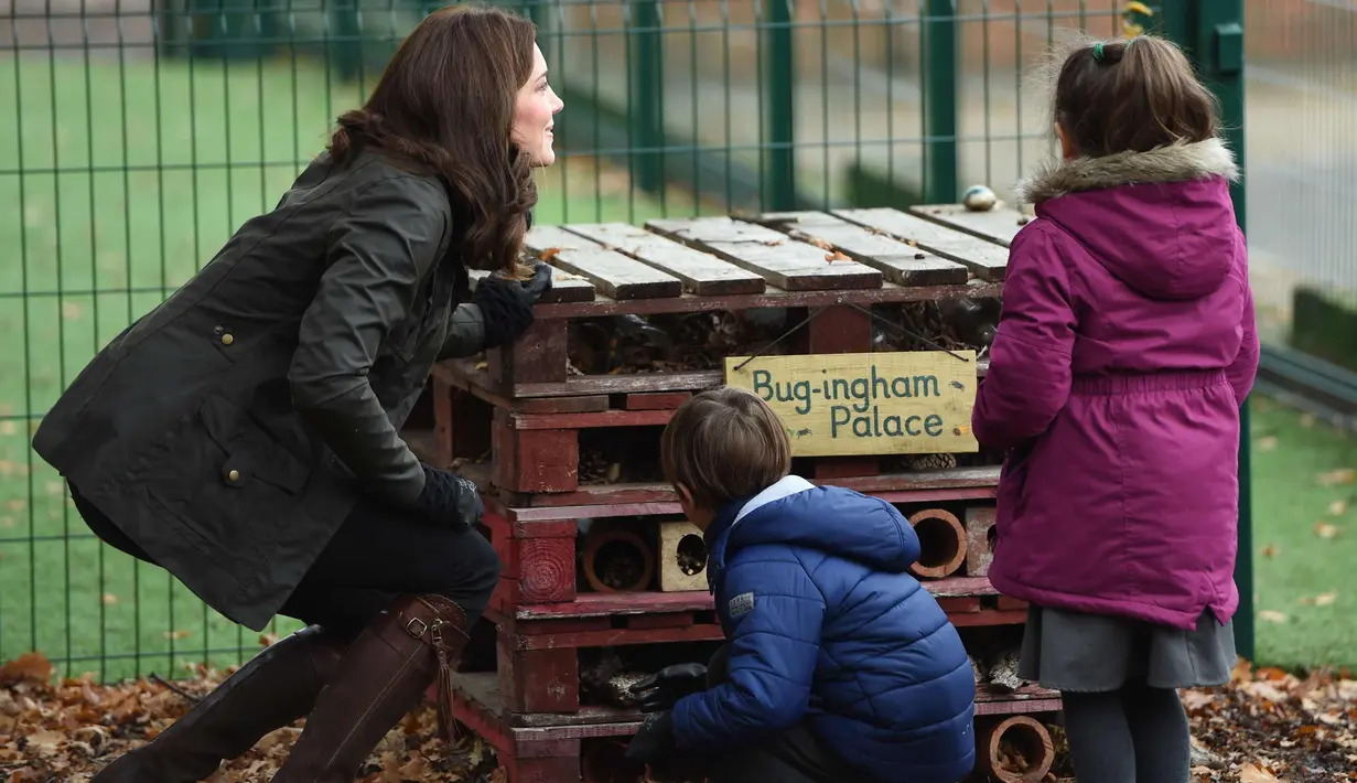 Kate Middleton saat bermain dengan anak-anak Sekolah Dasar Robin Hood di London, Inggris (29/11). Middleton tampil cantik mengenakan jaket berwarna cokelat dengan rambut terurai. (AFP Photo/Pool/Eddie Mulholland)