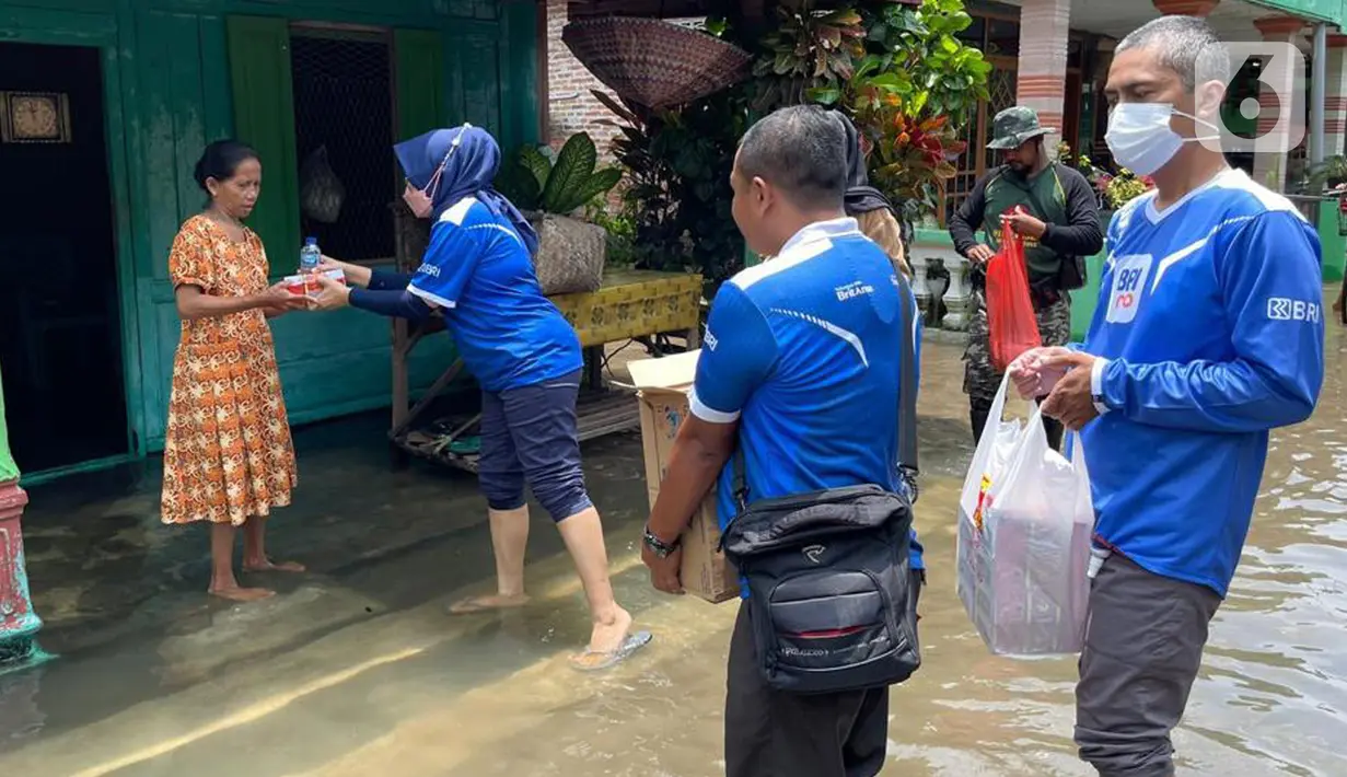 Pemimpin Cabang BRI Jombang Luthfi Riza Hartawan memberikan makanan cepat saji kepada warga terdampak banjir di Kecamatan Ngusikan, Jombang, Jawa Timur, Minggu (13/03/2022). Bantuan disalurkan secara bertahap dengan memprioritaskan masyarakat yang jauh dari jangkauan. (Liputan6.com/HO/CSRBRI)