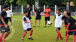 Dwight Yorke dan pelatih Manchester United Soccer Schools memperhatikan dengan serius anak-anak SSB Asiop Apacinti yang mengikuti Training Camp Ayo Indonesia Bisa (Liputan6.com/Helmi Fithriansyah)