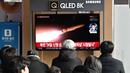 Orang-orang menonton layar televisi yang menampilkan siaran berita dengan file rekaman uji coba rudal Korea Utara, di sebuah stasiun kereta api di Seoul pada 28 Januari 2024. (Jung Yeon-je/AFP)
