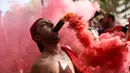 Seorang suporter Wales meletakkan suar di mulutnya setelah timnya lolos ke 16 Besar Piala Eropa 2016. (AFP/Bulent Kilic)