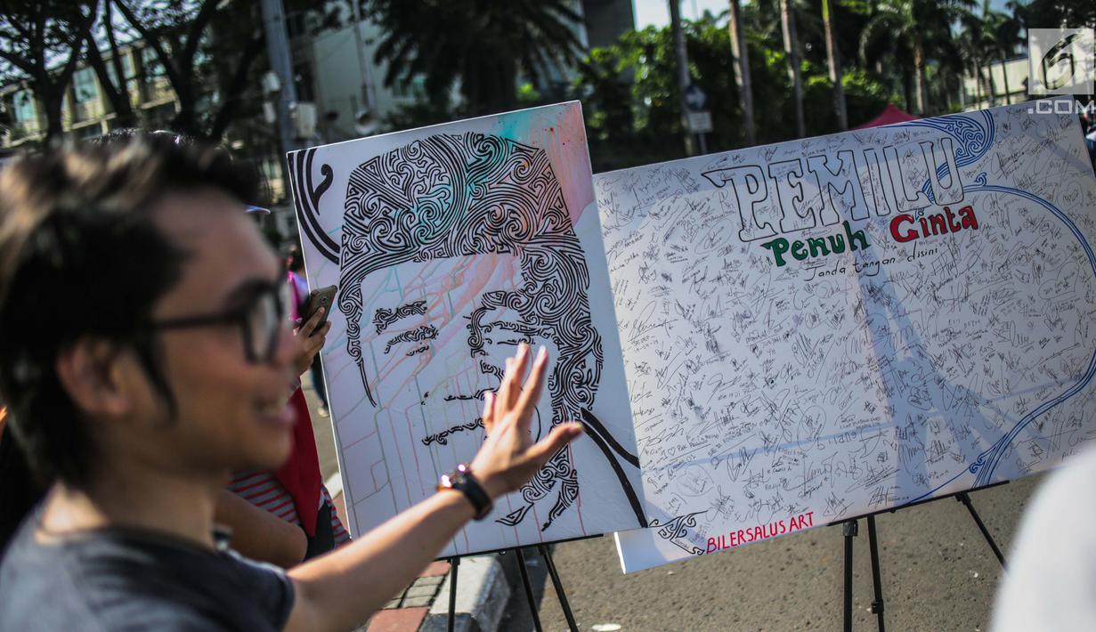 Sejumlah tanda tangan masyarakat dilukisan capres 01 yang bertema ‘ Pemilu Penuh Cinta’  saat Car Free day di kawasan Bundaran HI, Jakarta, MInggu (14/4). Kampanye tersebut untuk mengajak masyarakat untuk berpartisipasi dalam Pemilu secara Damai. (Liputan6.com/Faizal Fanani)