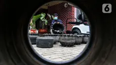Abdul Kholik (30) menyelesaikan pembuatan pot bunga dari ban bekas di Galeri Abdul Kholik, Tapos, Depok, Jumat (30/10/2020). Limbah ban bekas mobil Boogie Car atau mobil golf dimanfaatkan oleh Karang Taruna Kelurahan Cimpaeun sebagai bahan baku kerajinan pot bunga. (Liputan6.com/Johan Tallo)
