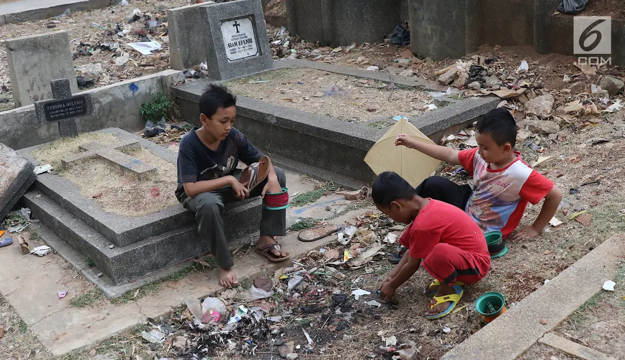 Anak-anak bermain layang-layang di TPU Menteng Pulo, Jakarta, Kamis (18/10). Padatnya pemukiman penduduk serta gedung bertingkat di kawasan tersebut menyebabkan anak-anak terpaksa bermain di tempat yang tidak semestinya. (Liputan6.com/Immanuel Antonius)