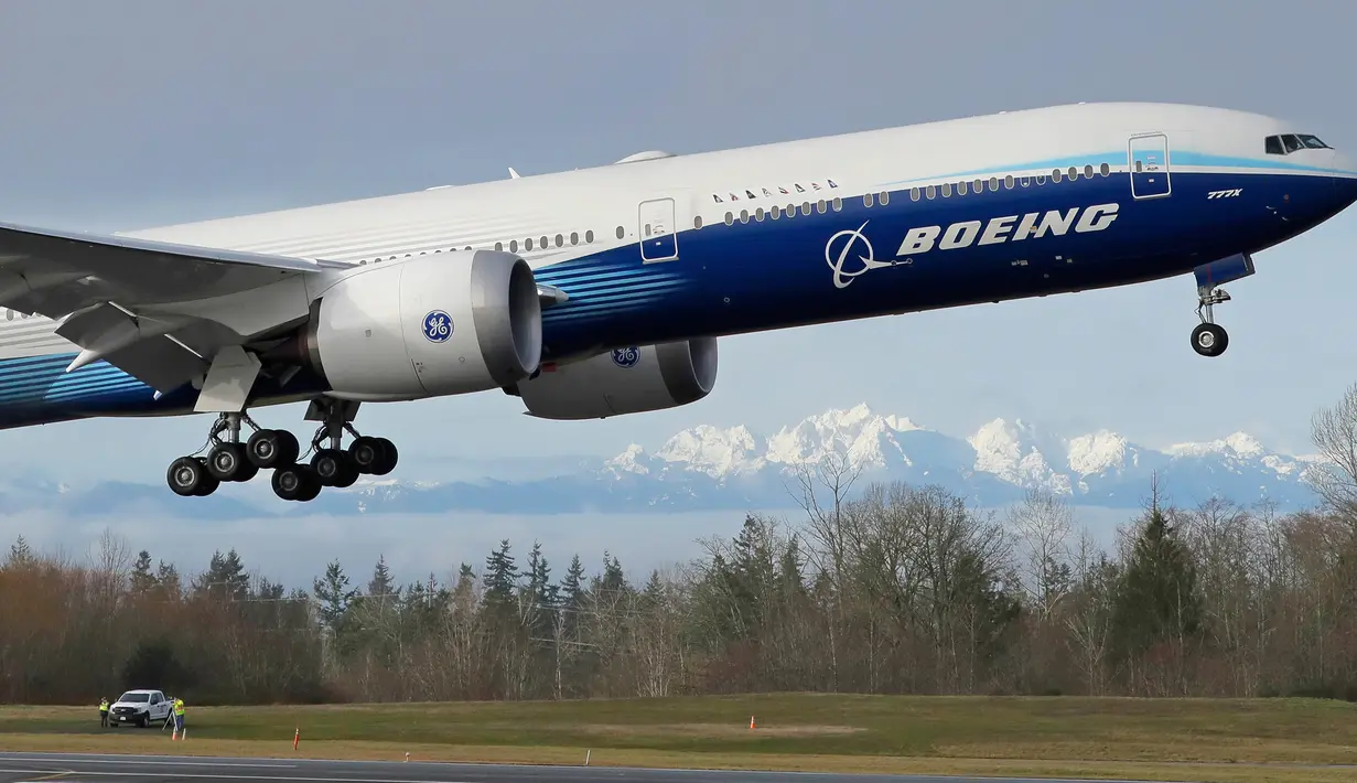 Pesawat Boeing 777X lepas landas pada penerbangan pertamanya dengan latar belakang Pegunungan Olimpiade di Paine Field, Everett di Washington, Sabtu (25/1/2020). Untuk pertama kalinya, Boeing sukses melakukan ujicoba terbang perdana pesawat jet bermesin ganda terbesar di dunia. (AP/Ted S. Warren)