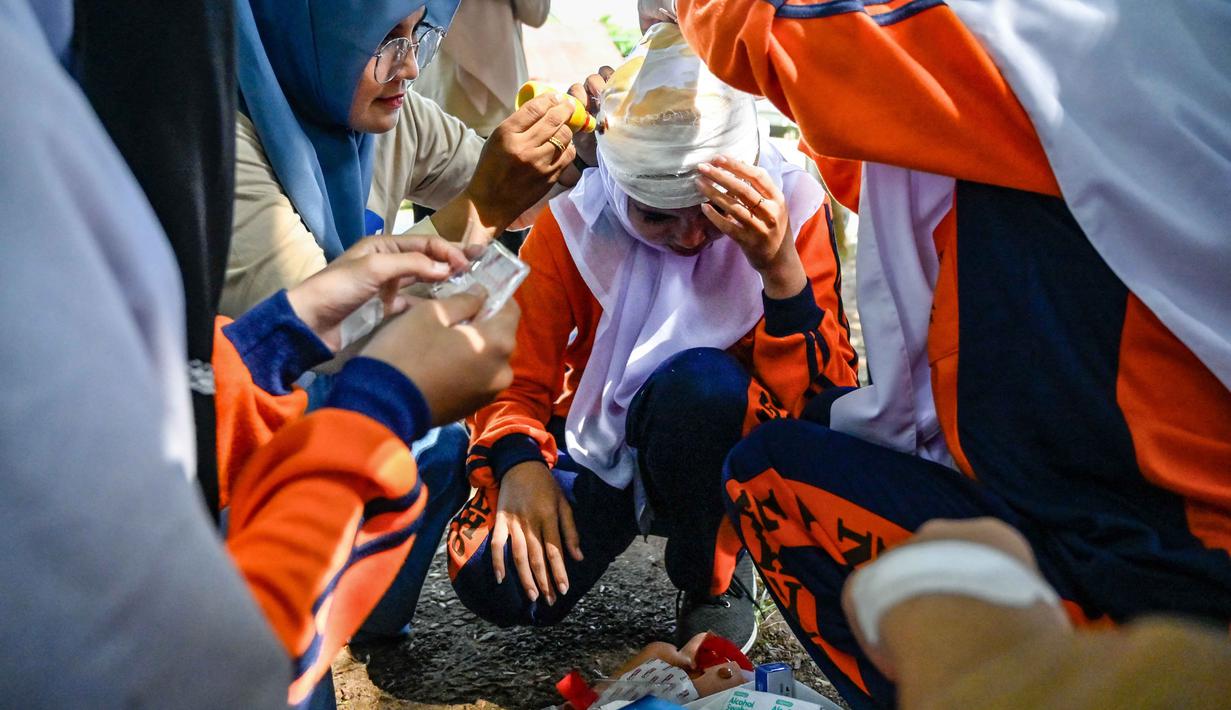 Sejumlah siswa Sekolah Menengah Atas (SMA) mengikuti simulasi gempa bumi dan tsunami untuk memperingati Hari Kesadaran Tsunami Sedunia di Lhoknga, Provinsi Aceh, pada Rabu 5 November 2025. Untuk diketahui, Hari Kesadaran Tsunami Sedunia diperingati setiap 5 November sebagai inisiatif global Perserikatan Bangsa-Bangsa (PBB) untuk membangun komunitas yang tangguh terhadap bencana. (CHAIDEER MAHYUDDIN/AFP)