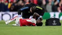 Penyerang Arsenal, Bukayo Saka, menerima perawatan setelah mendapatkan tekel dari kiper Bayern Munchen, Manuel Neuer, dalam laga leg pertama perempat final Liga Champions 2023/2024 di Emirates Stadium, Rabu (10/4/2024) dini hari WIB. (Ian Kington / IKIMAGES / AFP)
