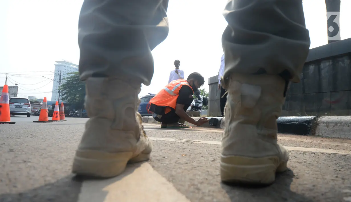 Petugas Satpol PP memberikan sanksi sosial mengcat pembatas jalan kepada warga pelanggar karena tidak menggunakan masker di Lebak Bulus, Jakarta, senin (14/09/2020). Pemerintah Provinsi DKI Jakarta memperketat kembali PSBB karena kasus Covid-19 terus mengalami peningkatan. (merdeka.com/Dwi Narwoko)