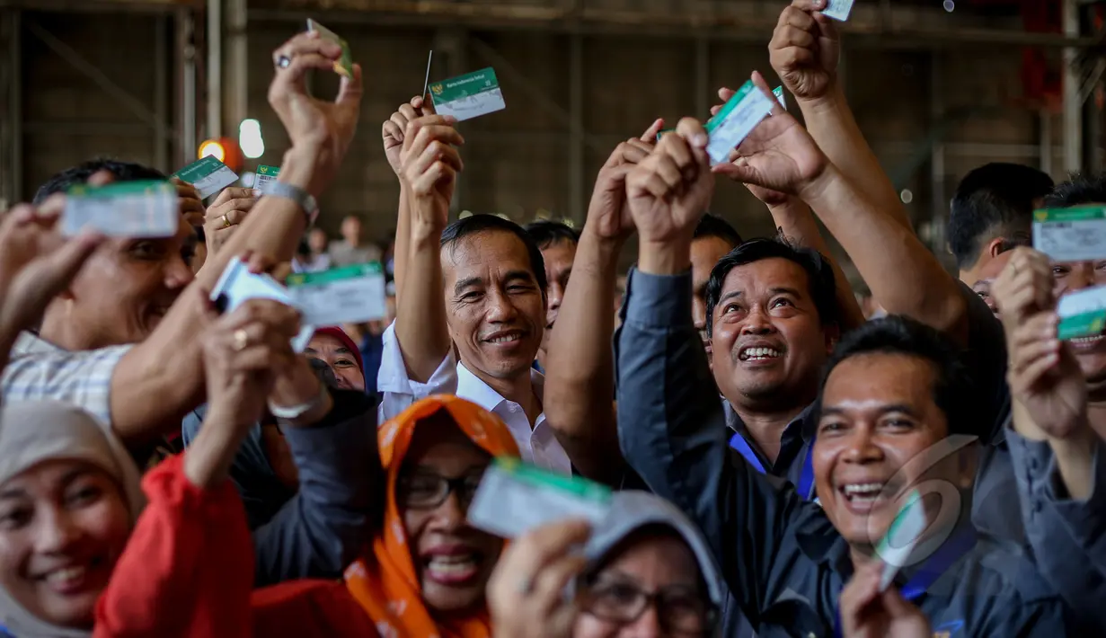 Presiden Joko Widodo (tengah) berfoto bersama para pekerja usai penyerahan Kartu Indonesia Sehat (KIS) untuk pekerja di PT Dok dan Perkapalan Kodja Bahari, Cilincing, Jakarta, Selasa (28/4/2015). (Liputan6.com/Faizal Fanani)