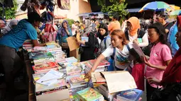 Warga memilih buku tulis yang dijajakan pedagang di sekitar Pasar Asemka, Jakarta, Rabu (5/7). Jelang bergantinya tahun ajaran baru, sejumlah warga berburu peralatan sekolah di kawasan Pasar Asemka Jakarta. (Liputan6.com/Helmi Fithriansyah)