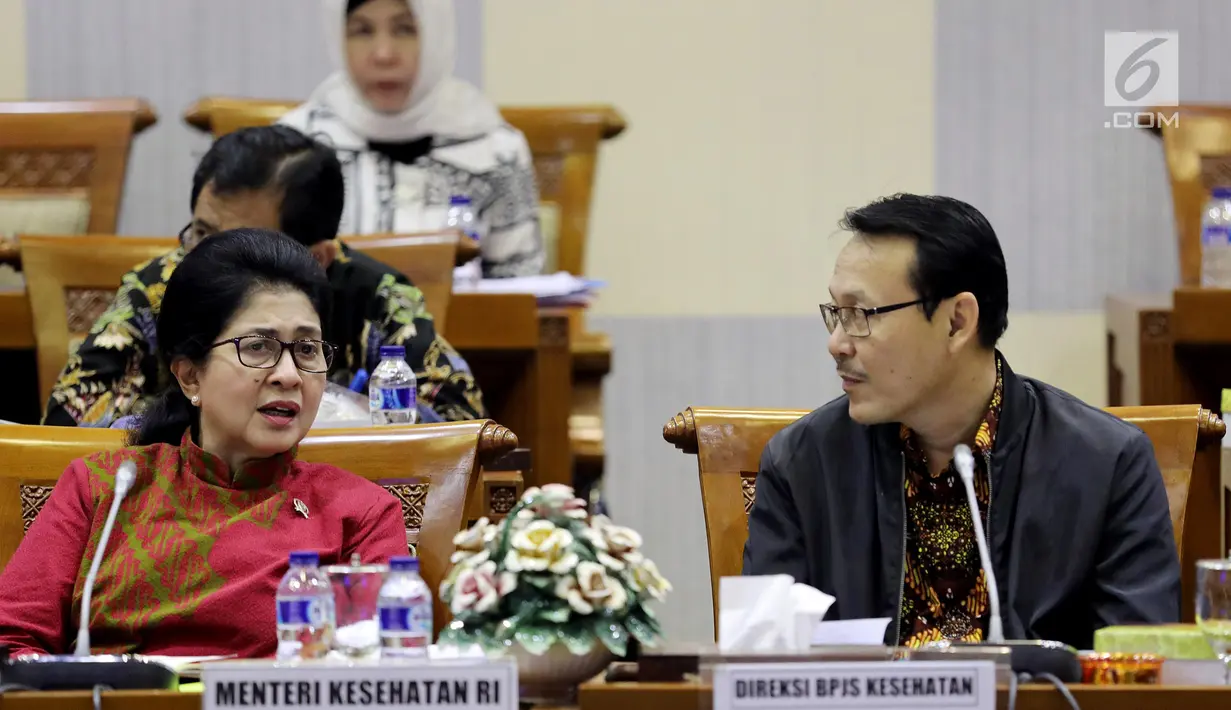 Menteri Kesehatan Nila Moeloek berbincang dengan Direksi PBJS Kesehatan, Fahmi Idris di sela rapat kerja dengan Komisi IX DPR di Kompleks Parlemen MPR/DPR-DPD, Senayan, Jakarta, Kamis (29/3). (Liputan6.com/JohanTallo)