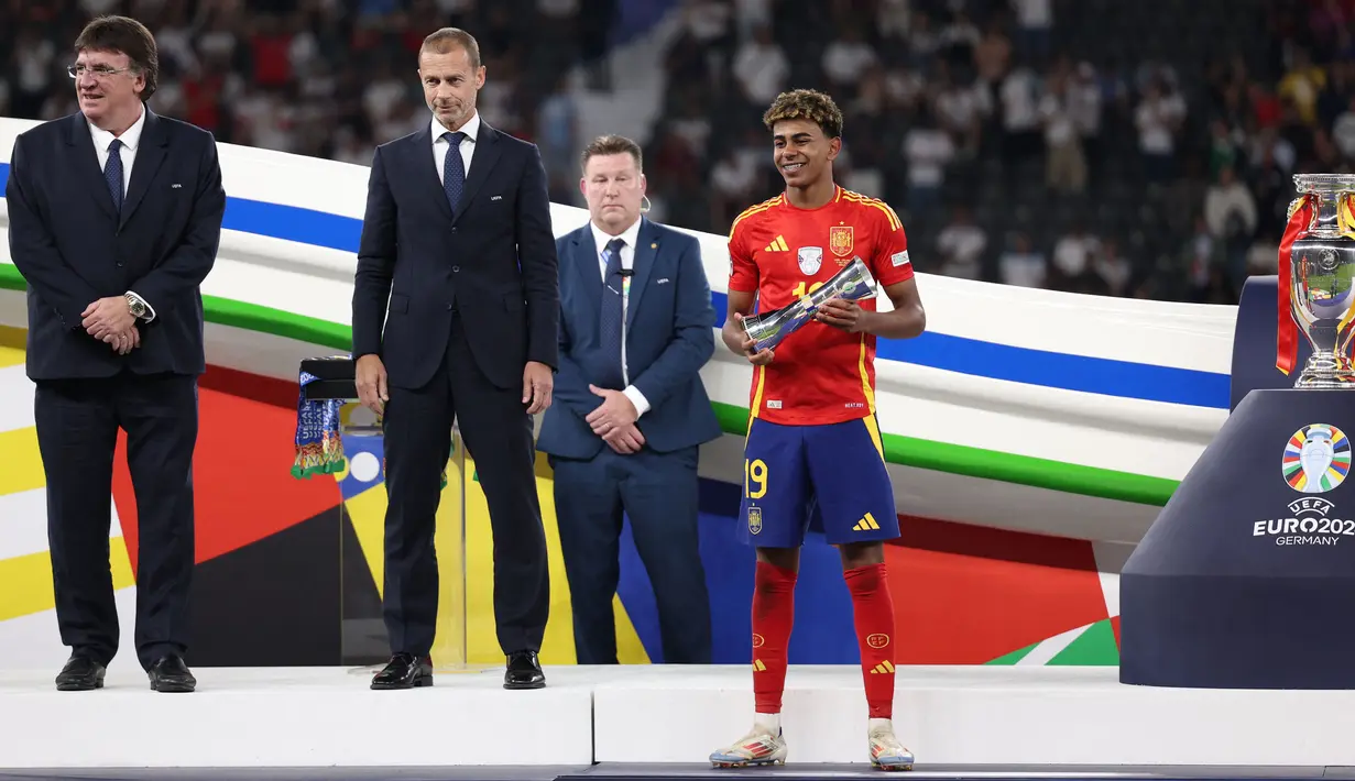 Penyerang Spanyol, Lamine Yamal menerima trofi pemain muda terbaik setelah memenangkan pertandingan final Euro 2024 melawan Inggris di Olympiastadion, Berlin pada 14 Juli 2024. (Adrian DENNIS/AFP)