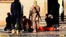 Militan ISIS bersiap mengeksekusi mati tiga pria yang dituduh homoseksual di Kota Raqqa, Suriah, 4 Mei 2015. Kelompok HAM Suriah di AS mengatakan dokumen yang diproduksi ISIS dapat membantu mengidentifikasi individu yang bertanggung jawab atas kekejaman di Suriah. (Militant website via AP)