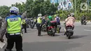Petugas kepolisian lalu lintas memberhentikan pengendara motor saat Operasi Zebra Jaya 2020 di kawasan Cawang, Jakarta, Senin (26/10/2020). Operasi Zebra Jaya dilaksanakan pada 26 Oktober-8 November 2020 untuk menekan jumlah pelanggaran lalu lintas. (Liputan6.com/Faizal Fanani)