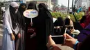 Komunitas Niqab Squad bersama pengunjung CFD berswafoto di kawasan Bundaran HI, Jakarta, Minggu (10/9). Selain melakukan Challenge kegiatan ini juga mengumpulkan donasi untuk Etnis Rohingnya. (Liputan6.com/Johan Tallo)