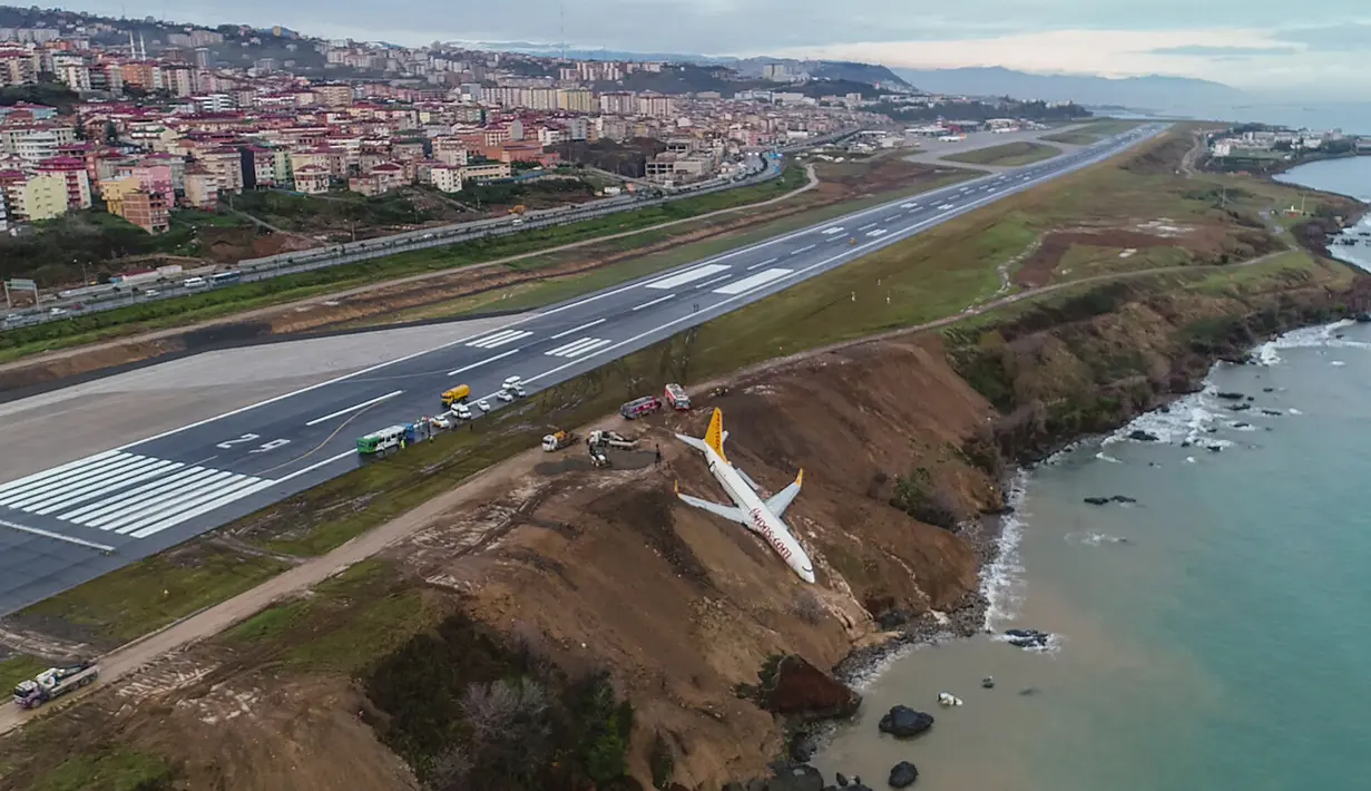 Sebuah pesawat dari maskapai Pegasus Airlines nyaris terperosok ke dalam laut di bandara Trabzon, Turki, Minggu (14/1). Peristiwa tersebut terjadi setelah pesawat mendarat dan  tergelincir dari landasan pacu. (DOGAN NEWS AGENCY/AFP)