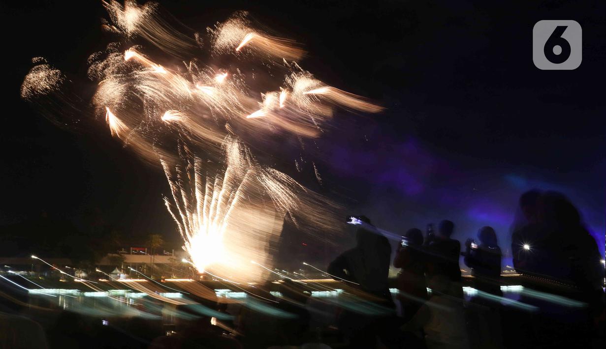 Warga menyaksikan pesta kembang api saat perayaan malam puncak Tahun Baru 2023 di Danau Archipelago, Taman Mini Indonesia Indah (TMII), Jakarta, Minggu (1/1/2023). Perayaan malam puncak Tahun Baru 2023 yang digelar Pemerintah Provinsi DKI Jakarta di TMII menghadirkan pesta kembang api yang berlangsung selama 15 menit. (Liputan6.com/Herman Zakharia)
