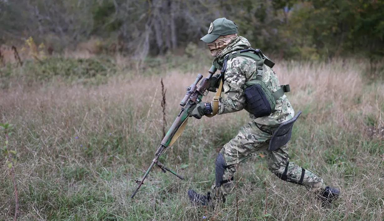Seorang rekrutan memegang senjata saat berlari pada pelatihan militer di lapangan tembak di wilayah Krasnodar, Rusia, 21 Oktober 2022. Presiden Rusia Vladimir Putin beberapa waktu lalu mengumumkan mobilisasi militer parsial. Akan ada 300.000 tentara cadangan dikirim berperang ke Ukraina. (AP Photo)