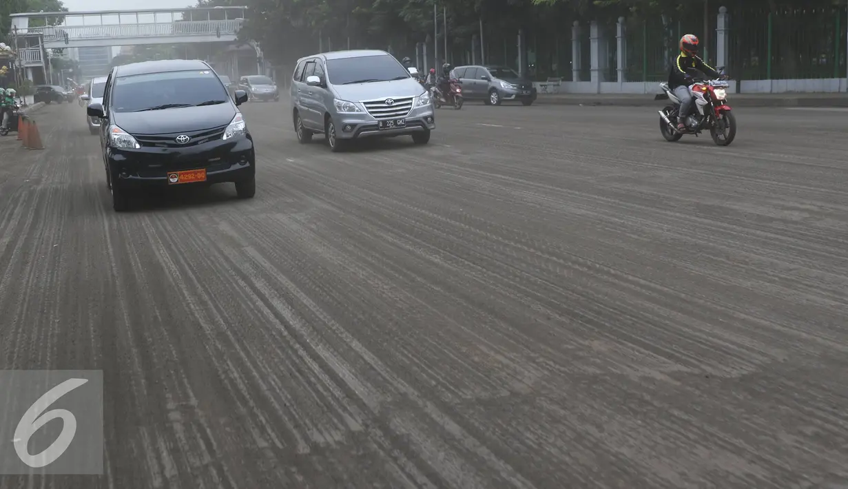 Kendaraan melintasi jalan yang sedang dalam proses perbaikan di kawasan Gambir, Jakarta, Selasa (14/6). Jalan yang rusak serta dipenuhi debu tersebut membuat pengendara harus lebih berhati-hati karena cukup berbahaya. (Liputan6.com/Immanuel Antonius)