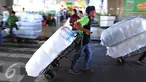 Pekerja mengangkut pakaian yang telah dikemas di kawasan Tanah Abang, Jakarta, Jumat (27/5). Jelang Ramadan penjualan pakaian yang akan di kirim ke berbagai daerah mengalami peningkatan. (Liputan6.com/Angga Yuniar)