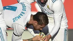 Pemain Real Madrid, Sergio Ramos (tengah) mencium sepatu rekannya Isco saat merayakan gol melawan Girona pada lanjutan La Liga Santander di Municipal de Montilivi stadium, Girona , (29/10/2017). Madrid kalah 1-2. (AFP/Josep Lago)